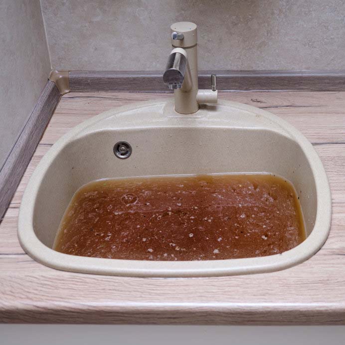 Sink in the kitchen with dirty water due to a clogged pipe Common Plumbing Problems and How to Avoid Them